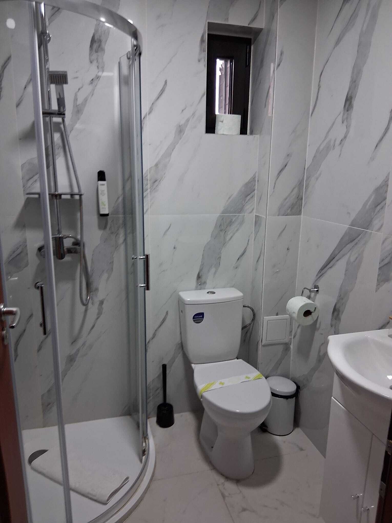 Un baño con ducha de vidrio, inodoro, bidé y lavamanos.