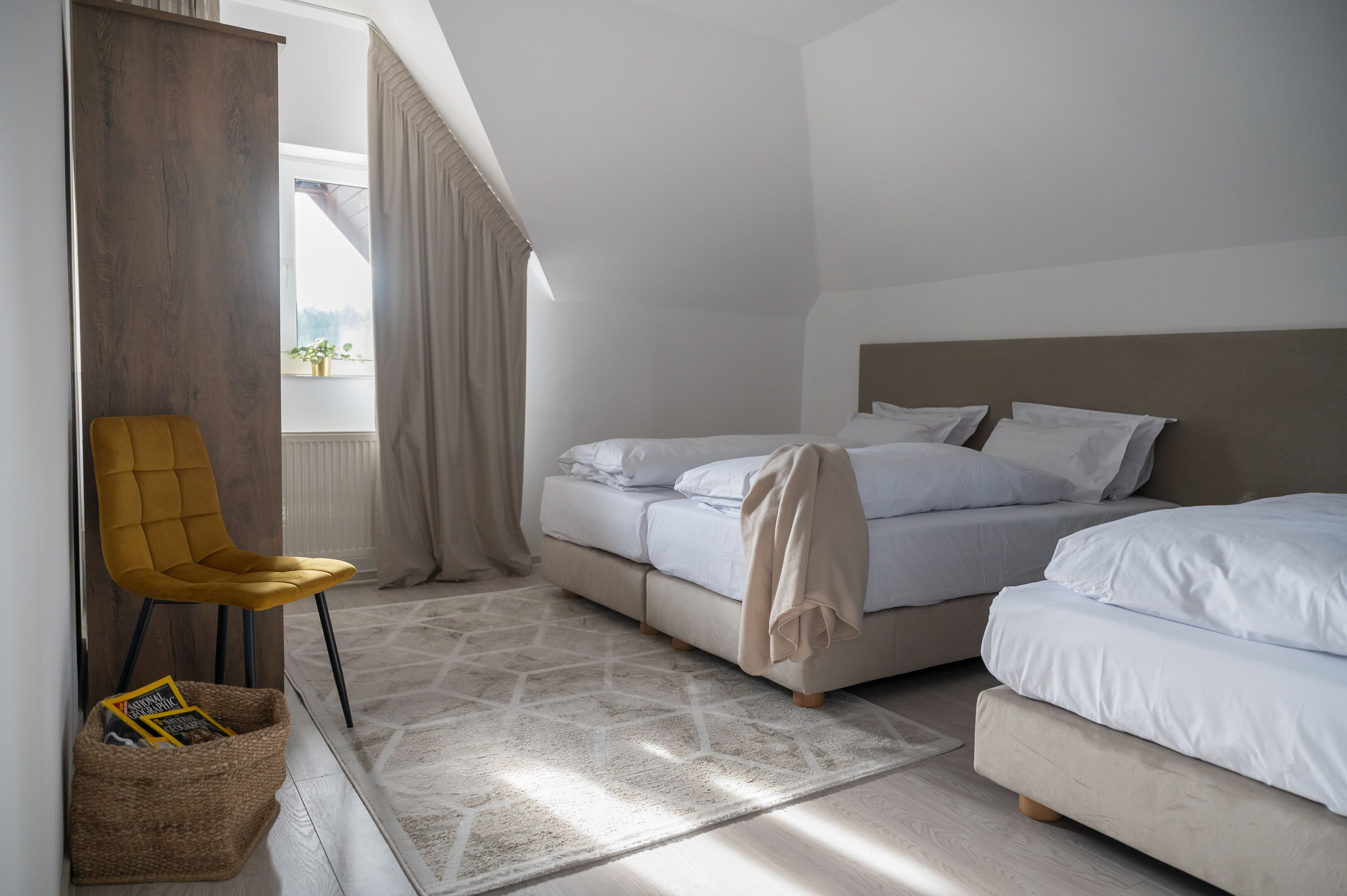Un dormitorio con cama, una silla y una ventana.