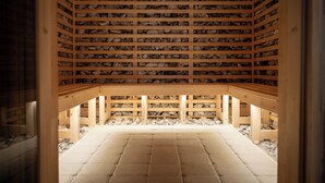 An interior with a stone floor, wooden beams, and a stone wall. - Monterai Resort (Brasov)