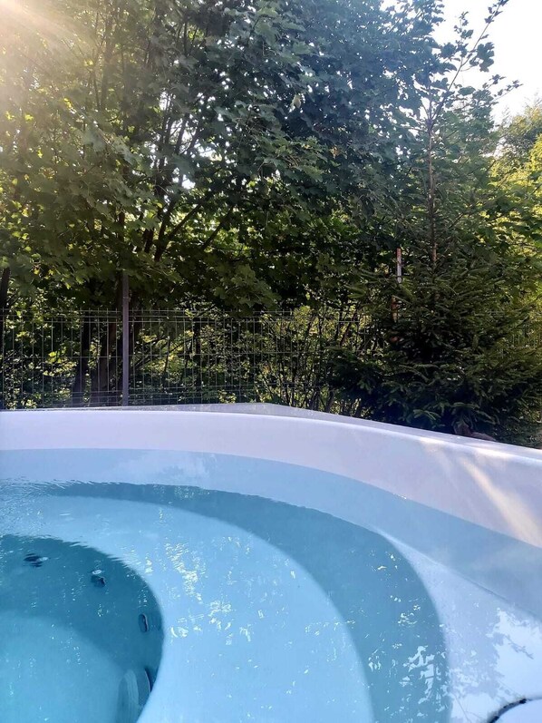 A hot tub surrounded by a dense forest.