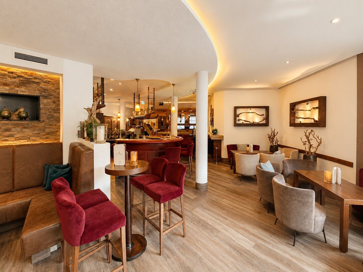 A modern hotel lobby with a bar area, seating arrangements, and a wooden accent wall.