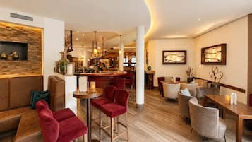 A modern hotel lobby with a bar area, seating arrangements, and a wooden accent wall.