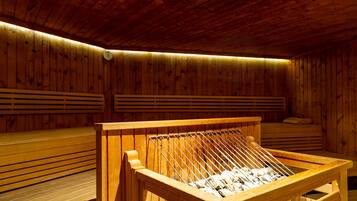 Una sauna con bancos de madera y un perchero metálico para toallas.