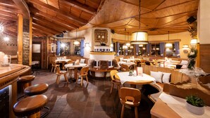 Un restaurante acogedor con interiores de madera, varias zonas de estar y una barra.