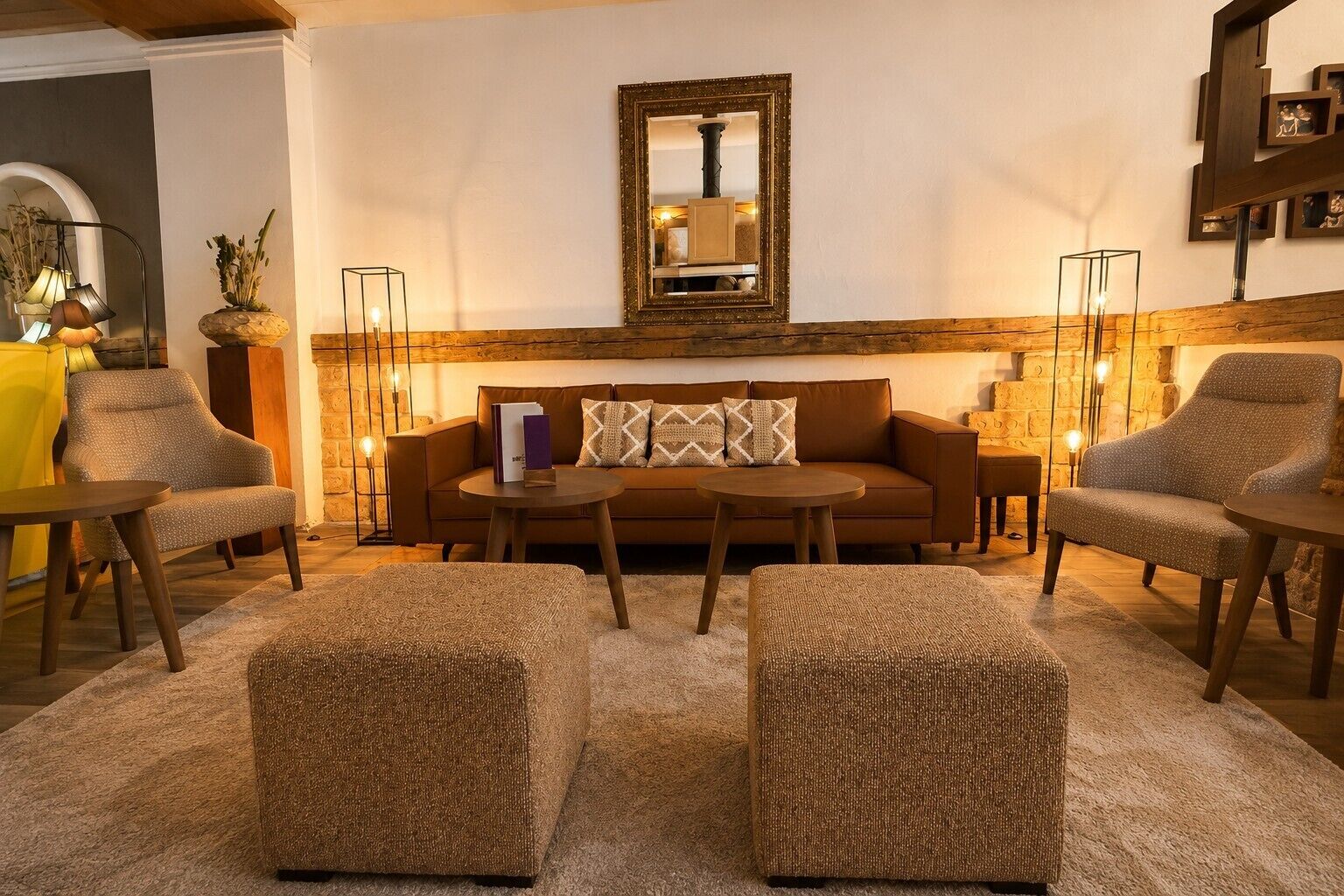 Een gezellige woonkamer met een bank, twee fauteuils, een salontafel en een open haard.