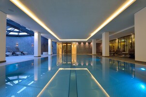 Una piscina techada, sillones reclinables de piscina
