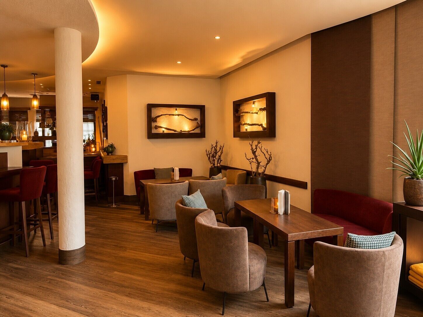 Un restaurante con piso de madera, asientos acolchados y obras de arte colgadas en la pared.