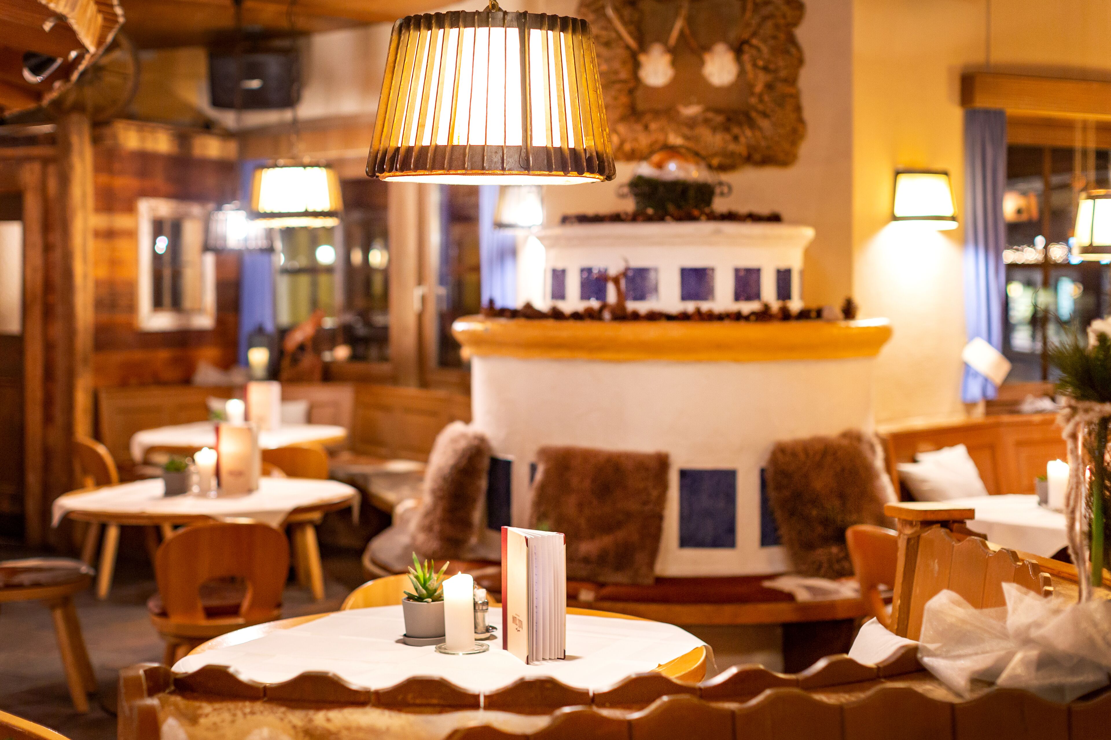 Un acogedor interior de restaurante con mesas y sillas de madera, y una isla central con un pastel.