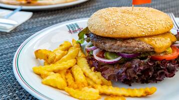 A plate with a hamburger, fries, and a flag.