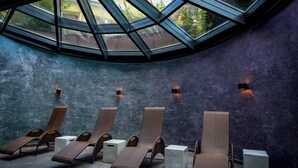 Un área de spa con seis sillones reclinables y tres pedestales blancos, bajo un tragaluz grande.