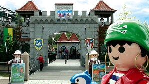 Una entrada que parece un castillo, con un cartel que dice "EINGANG playmobil FunPark".