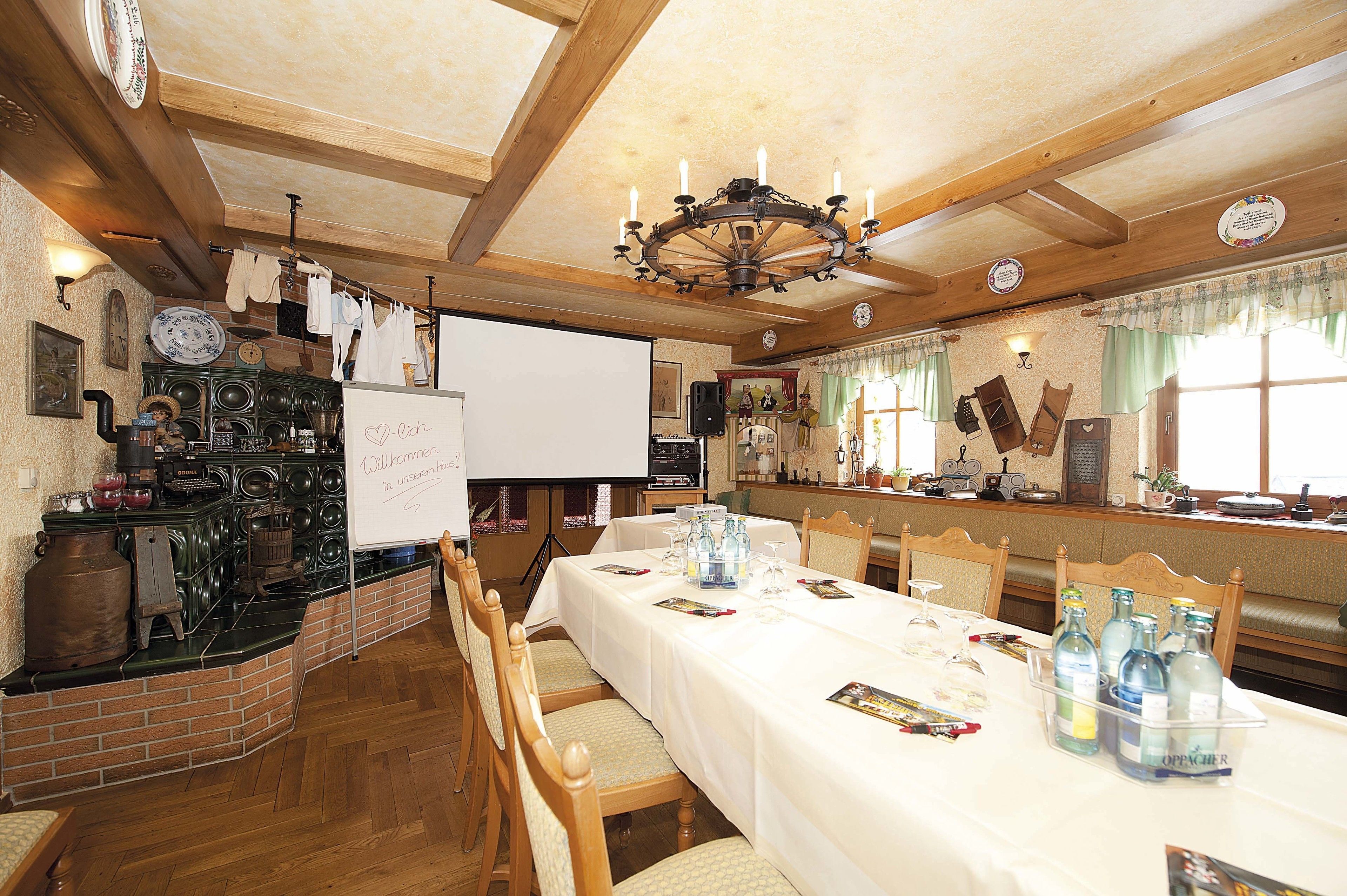 A dining area with a long table set for a meal, surrounded by wooden chairs.