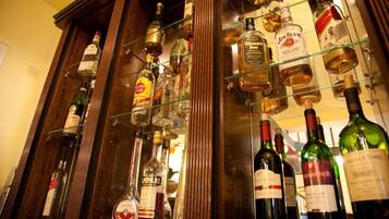 Variedad de botellas de licor exhibidas en estanterías en un bar.