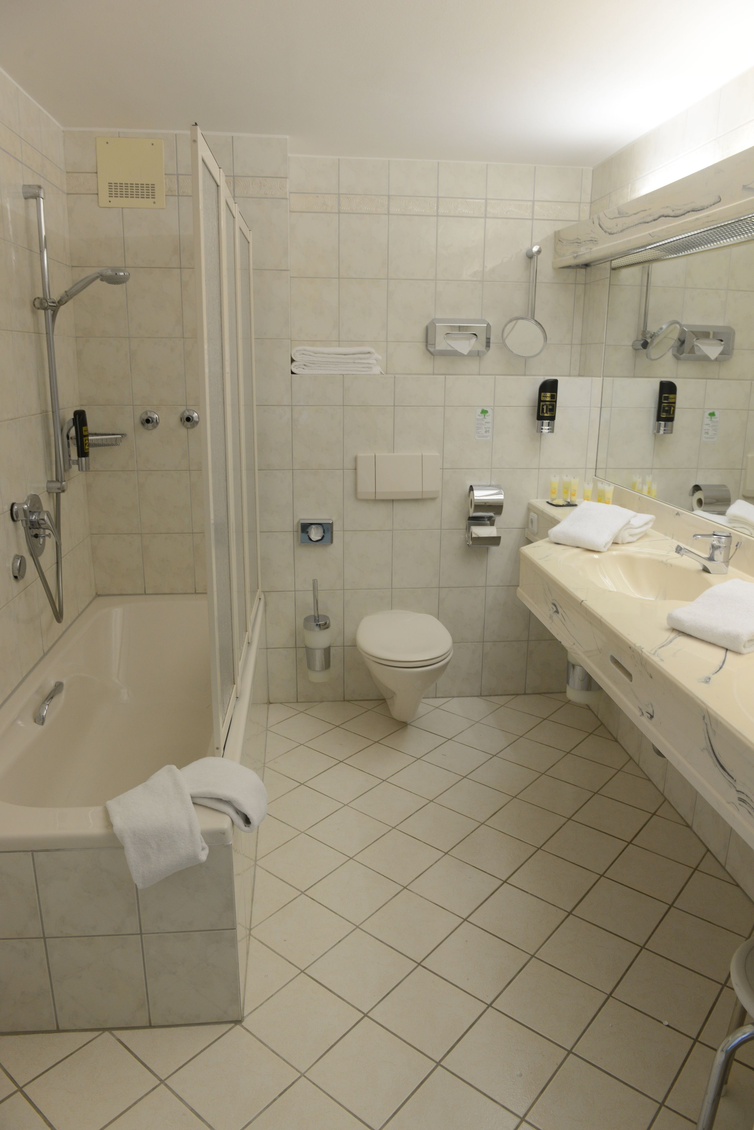 A modern bathroom with a bathtub, toilet, and sink.
