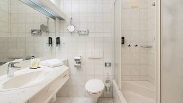 Een moderne badkamer met een grote spiegel, twee wastafels, een toilet en een douche.
