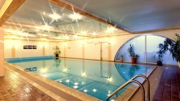 Una piscina techada, sillones reclinables de piscina