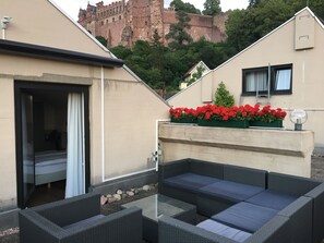 Relax in a serene garden setting with a picturesque view of a historic castle.