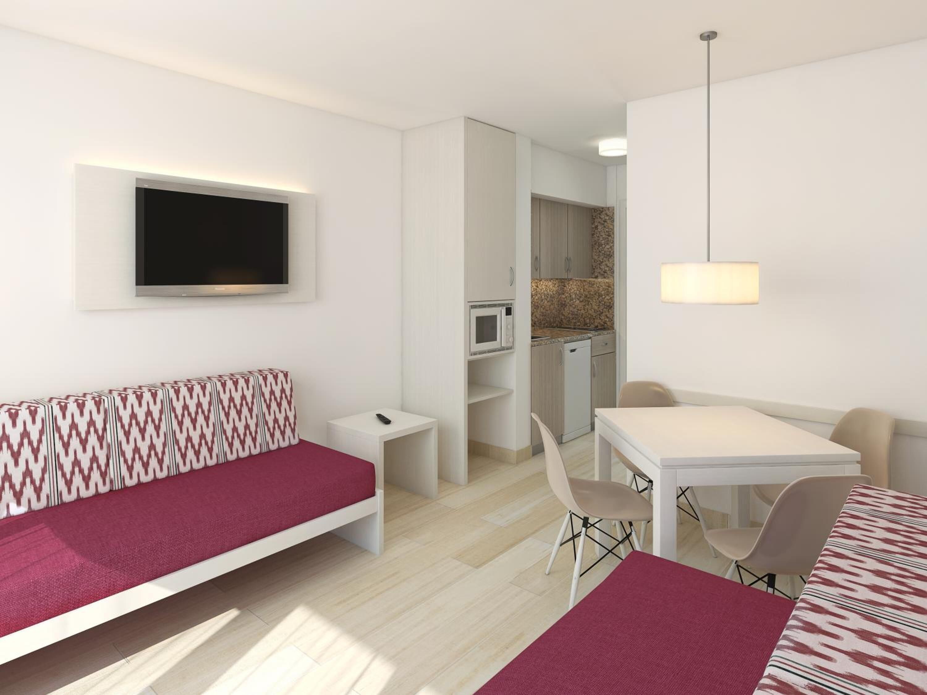A modern, compact room with a sofa, a dining table, and a kitchenette.