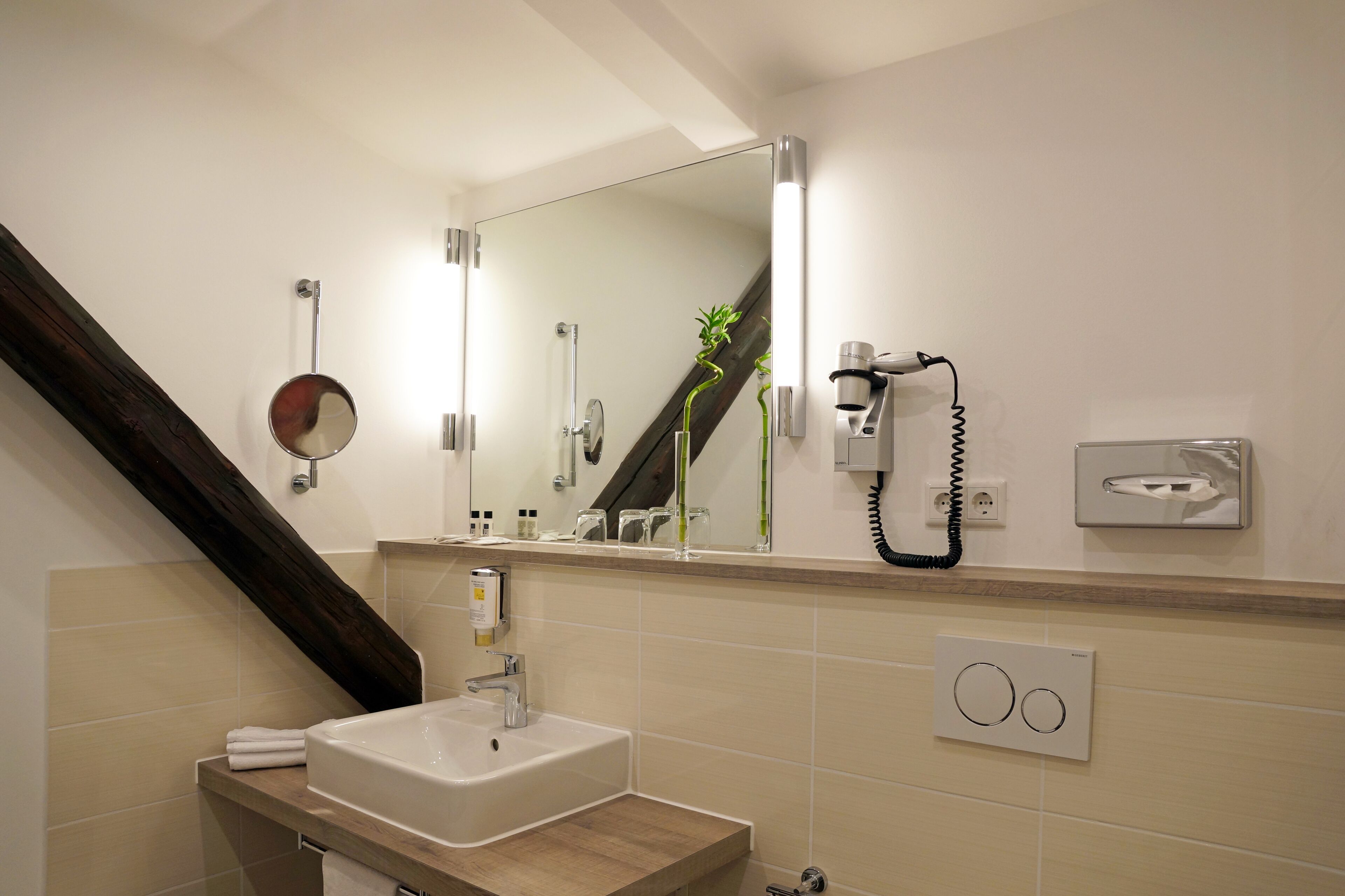 A bathroom with a sink, mirror, towel rack, and a telephone.