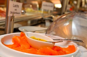 A buffet area with a sign indicating 'Lachs mit Dill-Senf'. - Hünerbein's Posthotel (Bissendorf)