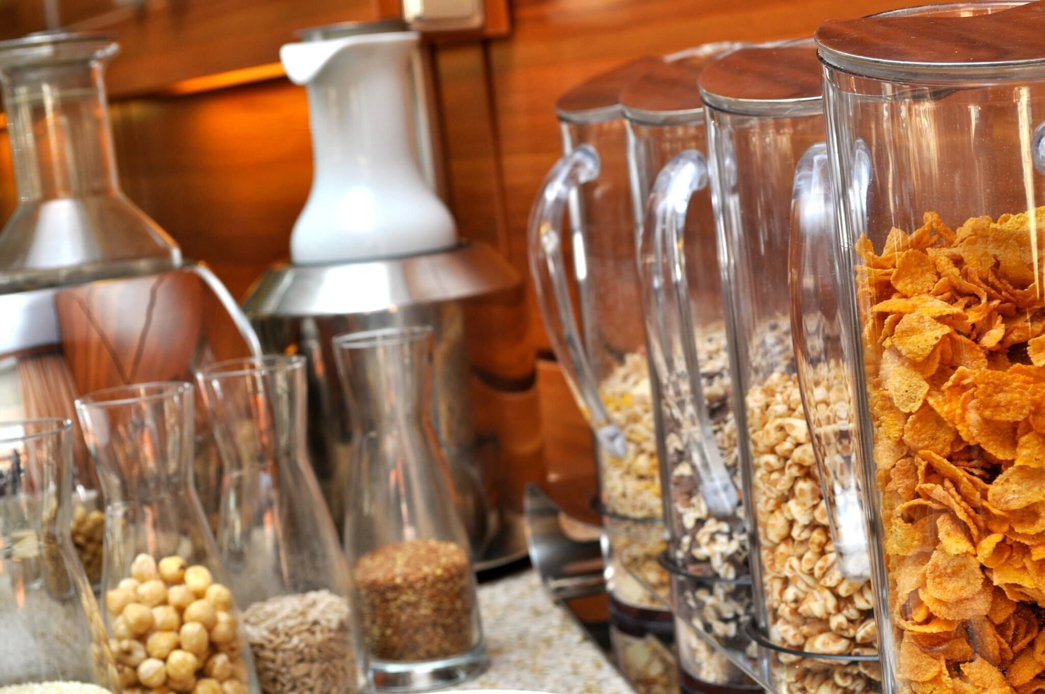 Diversos alimentos en recipientes de vidrio, como cereales y frutos secos, dispuestos sobre una encimera.