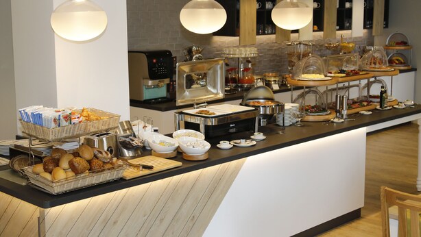 Montaje de bufé con diversas opciones de comida y una estación de café.