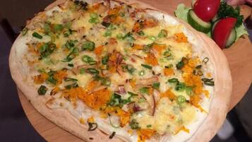 Una pizza con ingredientes sobre una tabla de madera.