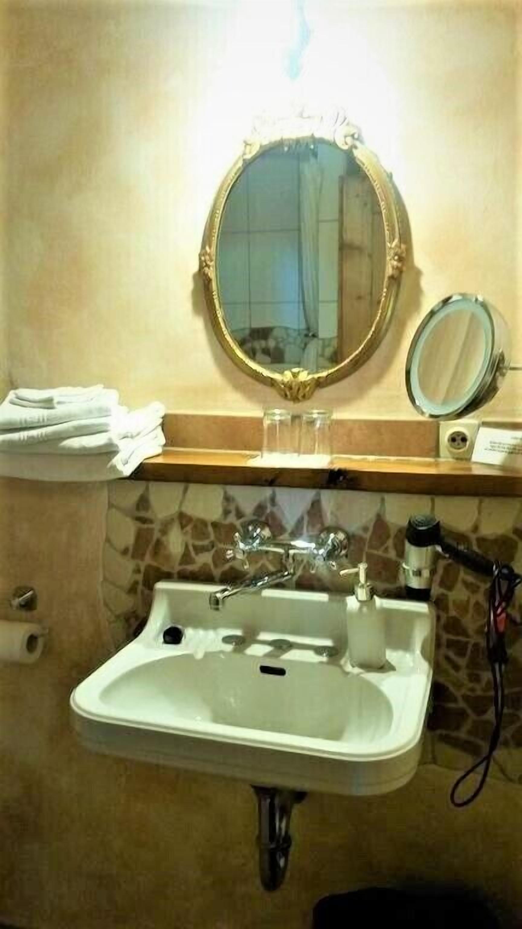 A bathroom with a white sink, a mirror, and a towel rack.