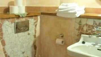 Un baño con inodoro, lavabo y espejo.