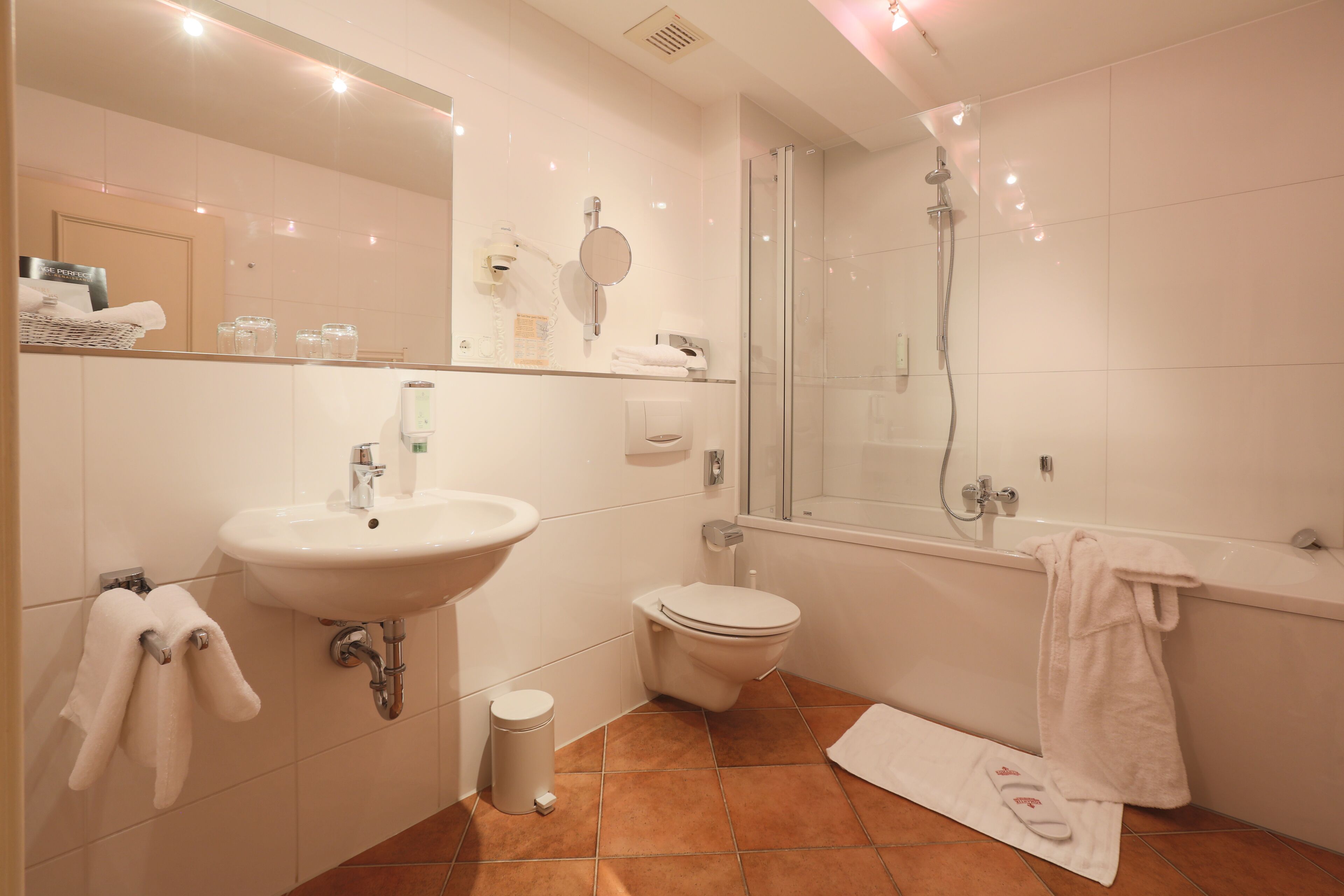 Een moderne badkamer met een wastafel, toilet en douche.