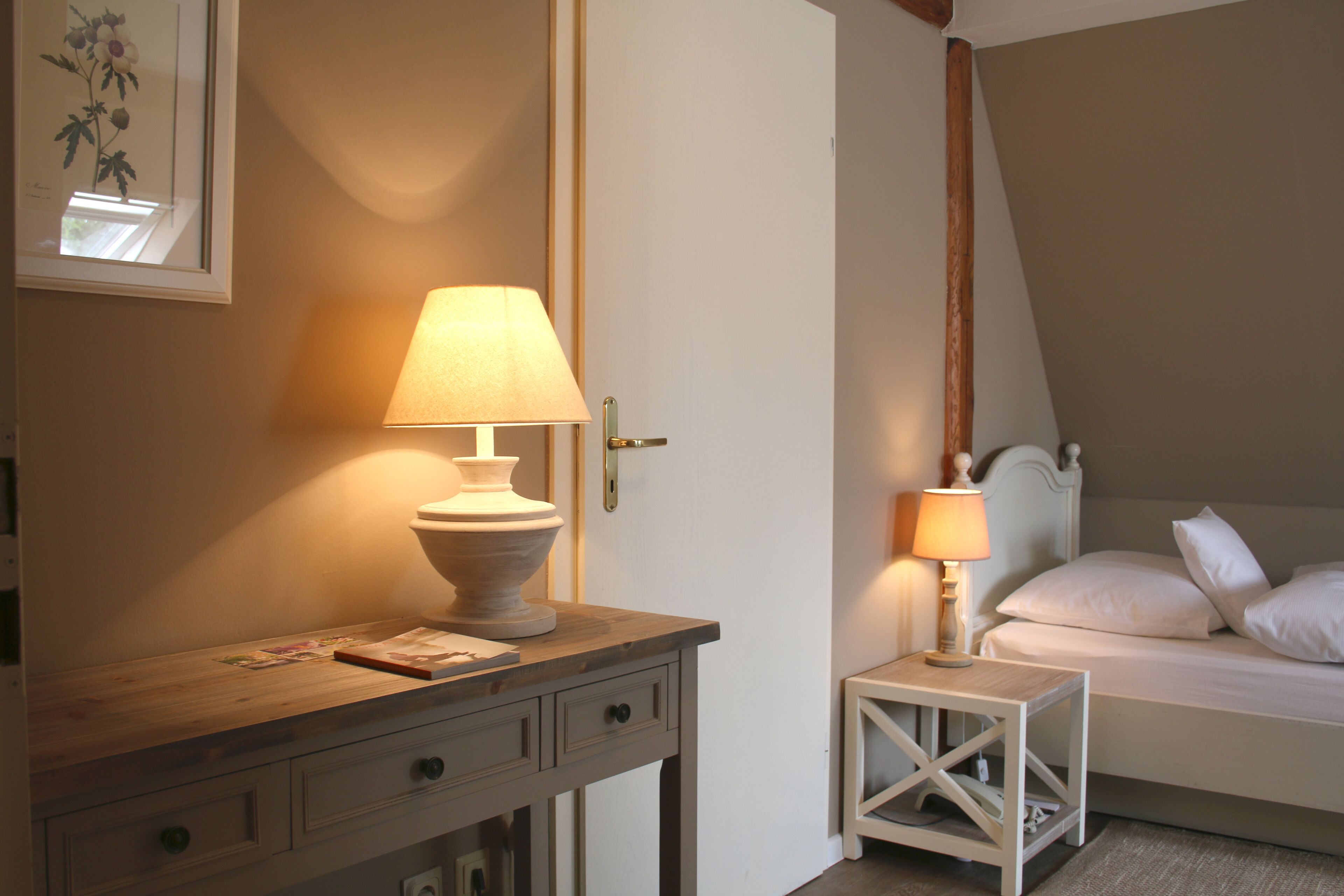 A bedroom with a bed, bedside tables, and a nightstand with lamps.