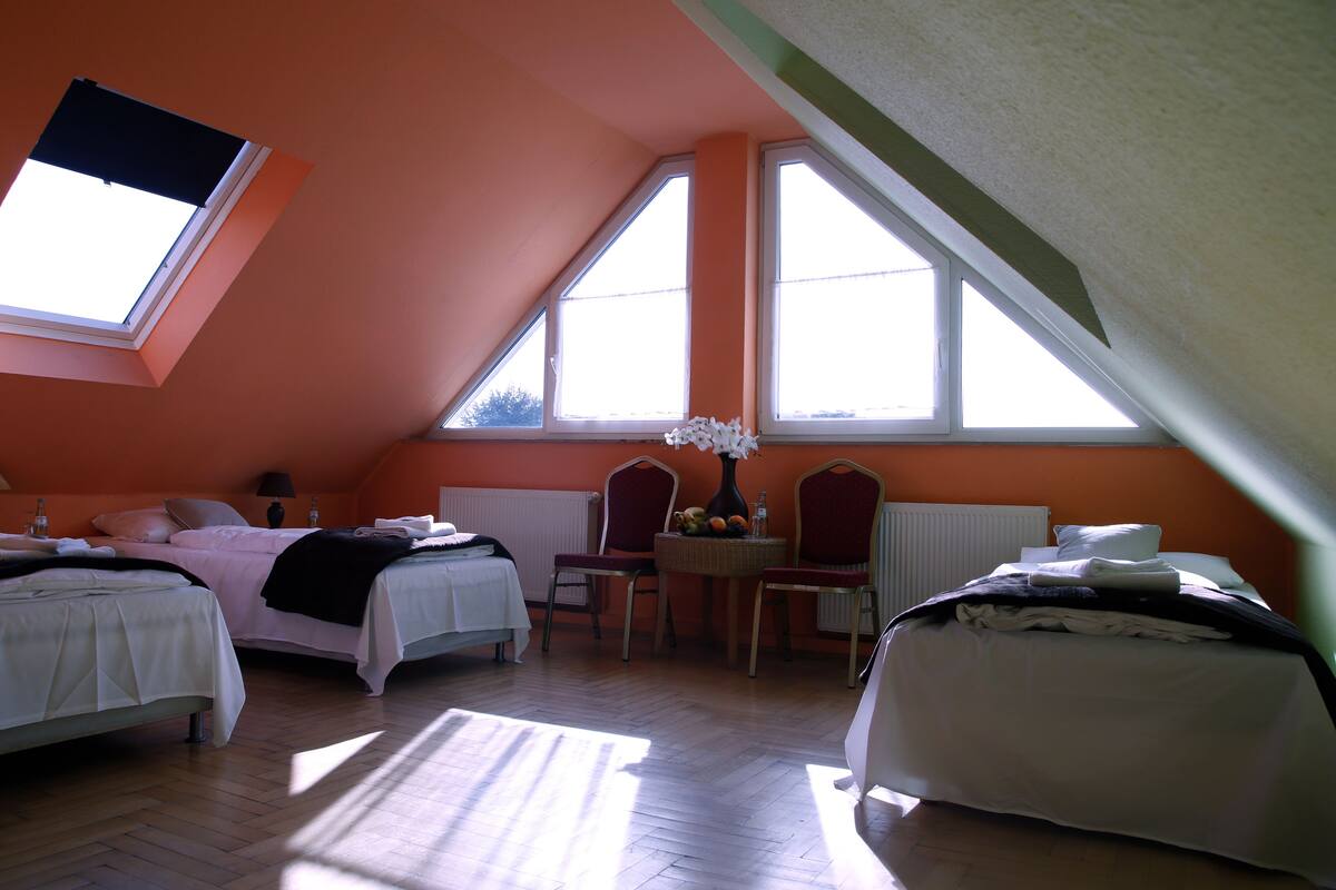 Een slaapkamer met twee bedden, een tafel met een vaas en een stoel.