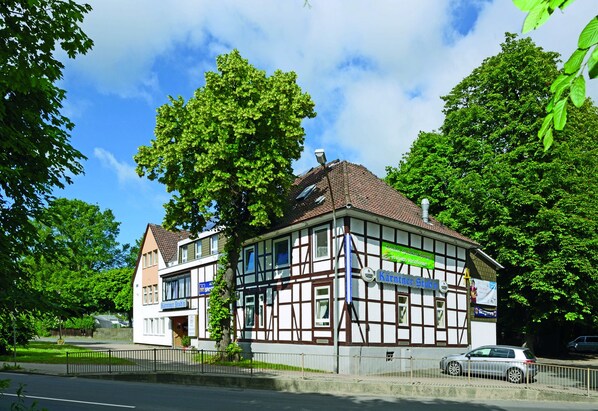 Un bâtiment traditionnel à colombages, avec une enseigne indiquant « Käntnerstuben », et une voiture garée devant.