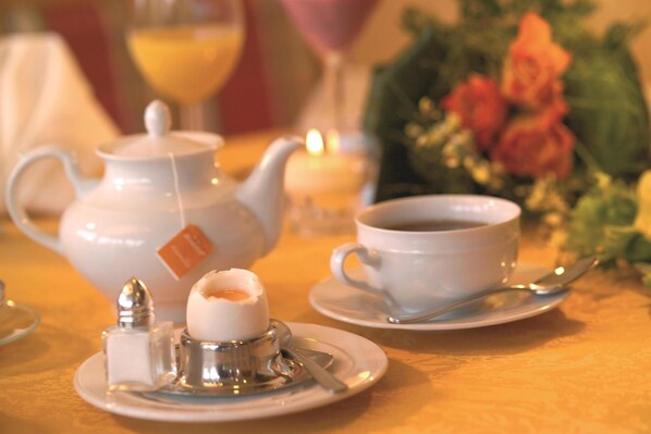 A table set with a teapot, sugar cubes, a cup of coffee, and a candle. - Kishotel Am Kurpark (Bad Soden-Salmuenster)