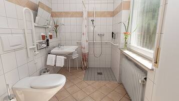 A modern bathroom with a toilet, sink, and shower.