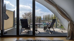 Una habitación con puerta corrediza de vidrio que da a un patio al aire libre con mesa y sillas.