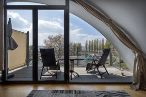 A room with a sliding glass door leading to an outdoor patio with a table and chairs.