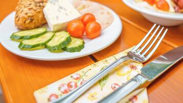 Una mesa preparada para una comida, con platos de comida, una taza y cubiertos.