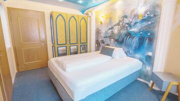 Een slaapkamer met een bed, een kledingkast en een muurschildering van een waterval.