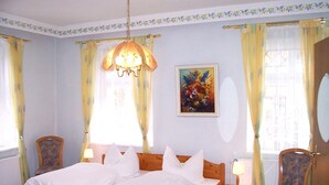 Een slaapkamer met een houten bed, twee nachtkastjes met lampen, een stoel en een schilderij aan de muur.