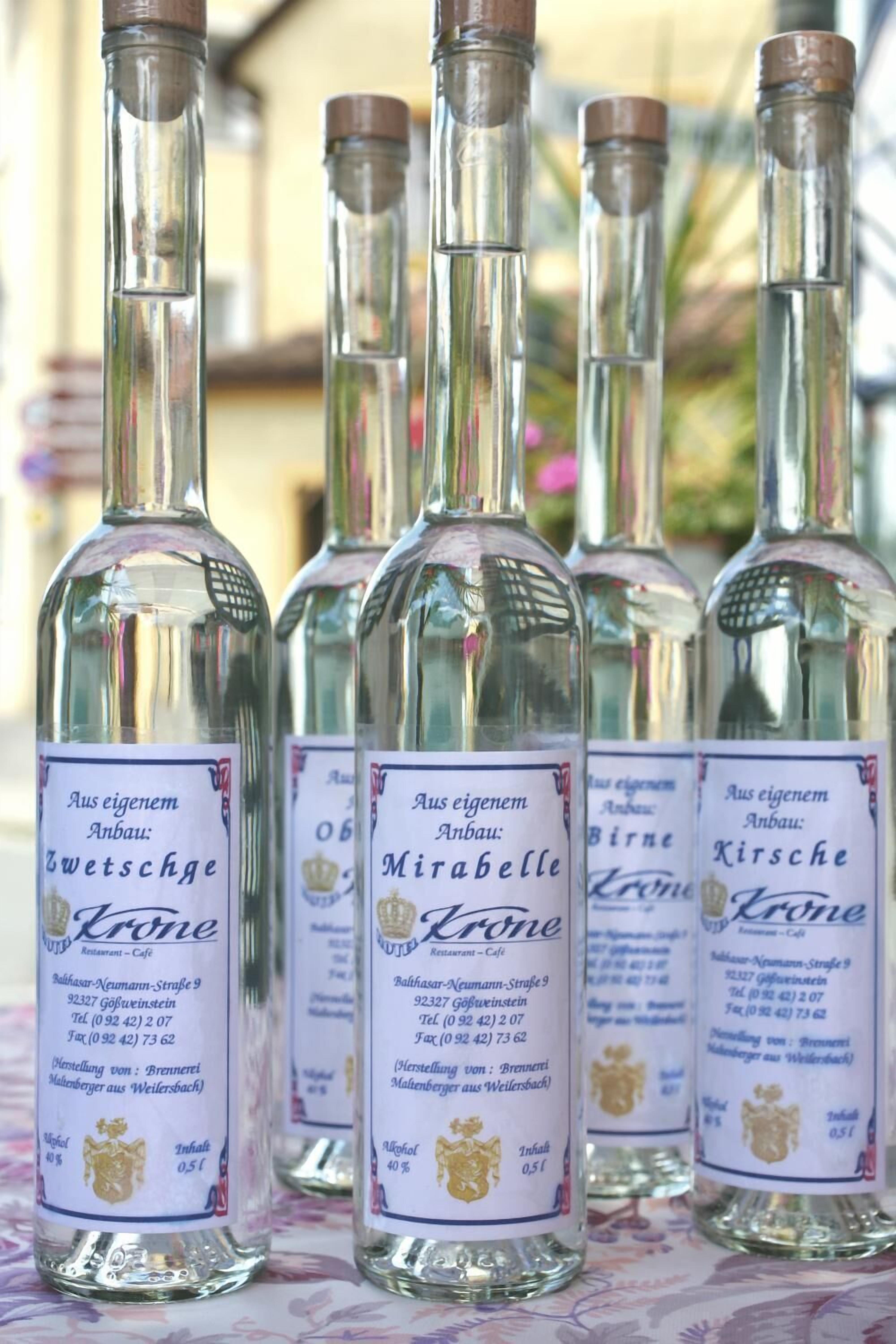 Four bottles of Zwetschgen Krone wine with labels indicating they are from a local brewery.