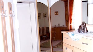 Een kamer met een houten kast, een spiegel en een kamerbreed tapijt met een patroon.