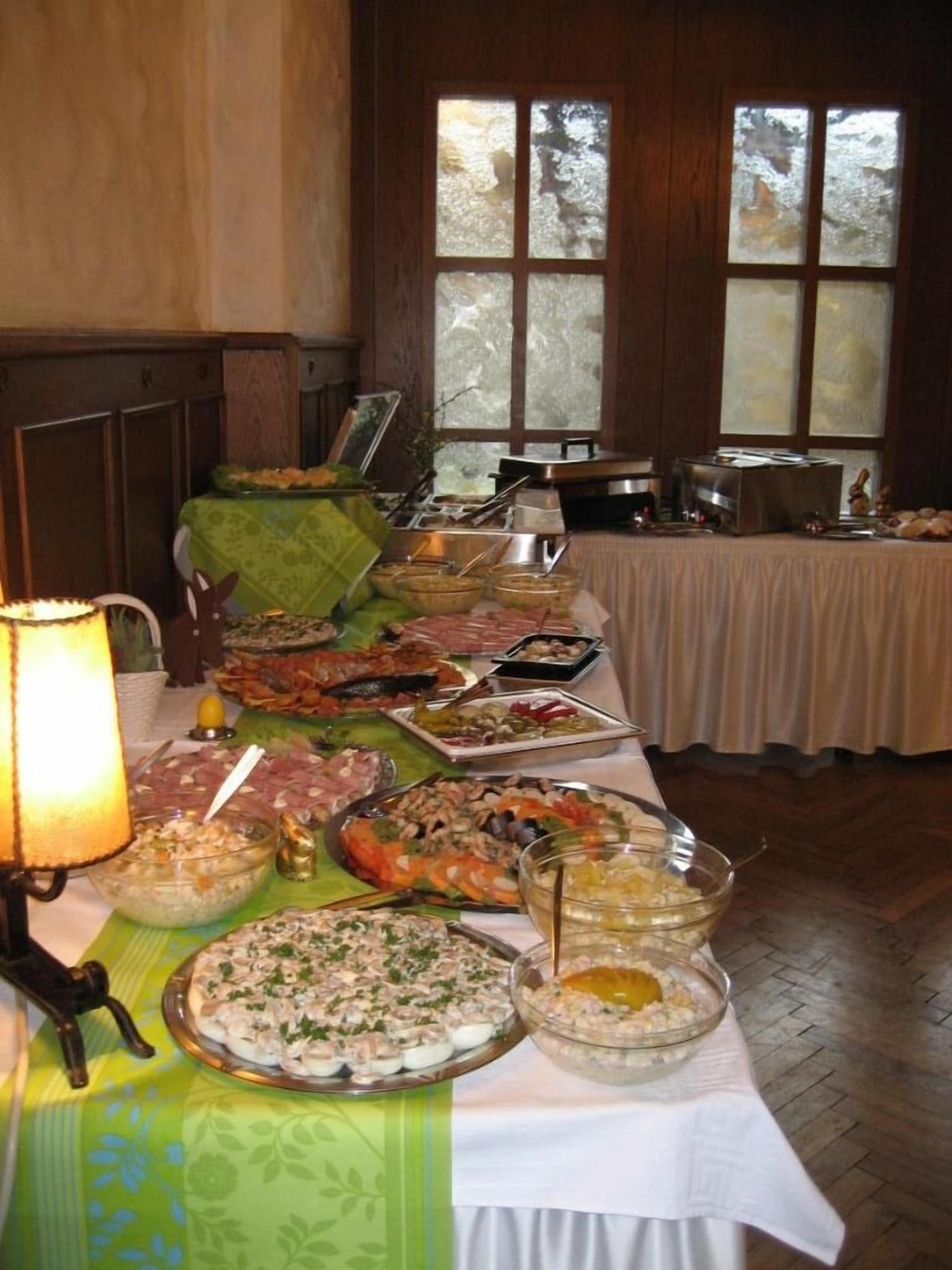 Una mesa de buffet con diversos platos, una lámpara y vistas a una ventana con vidrio esmerilado.