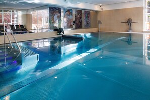 A large indoor swimming pool with clear blue water, a diving board, and a lifeguard chair. - Hotel SPA Husseren Collections - Proche Colmar - Eguisheim (Husseren-les-Chateaux)
