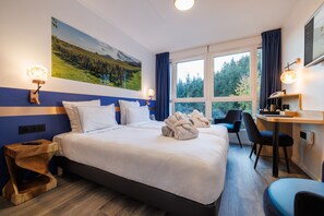 A hotel room with a large bed, a desk, and a chair, a painting on the wall, and a window with curtains. - Hotel SPA Husseren Collections - Proche Colmar - Eguisheim (Husseren-les-Chateaux)