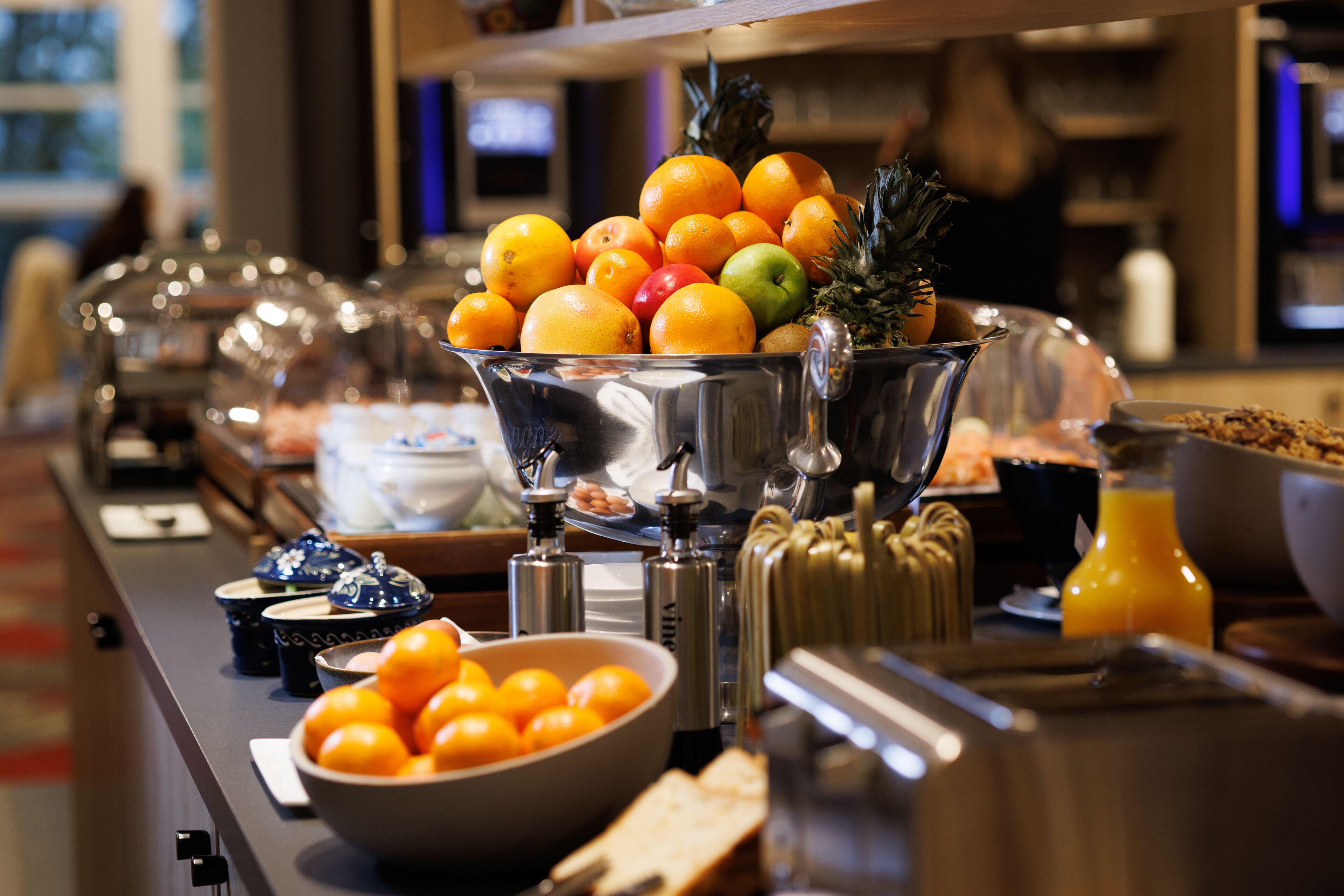 A buffet setup with a variety of fruits and beverages.