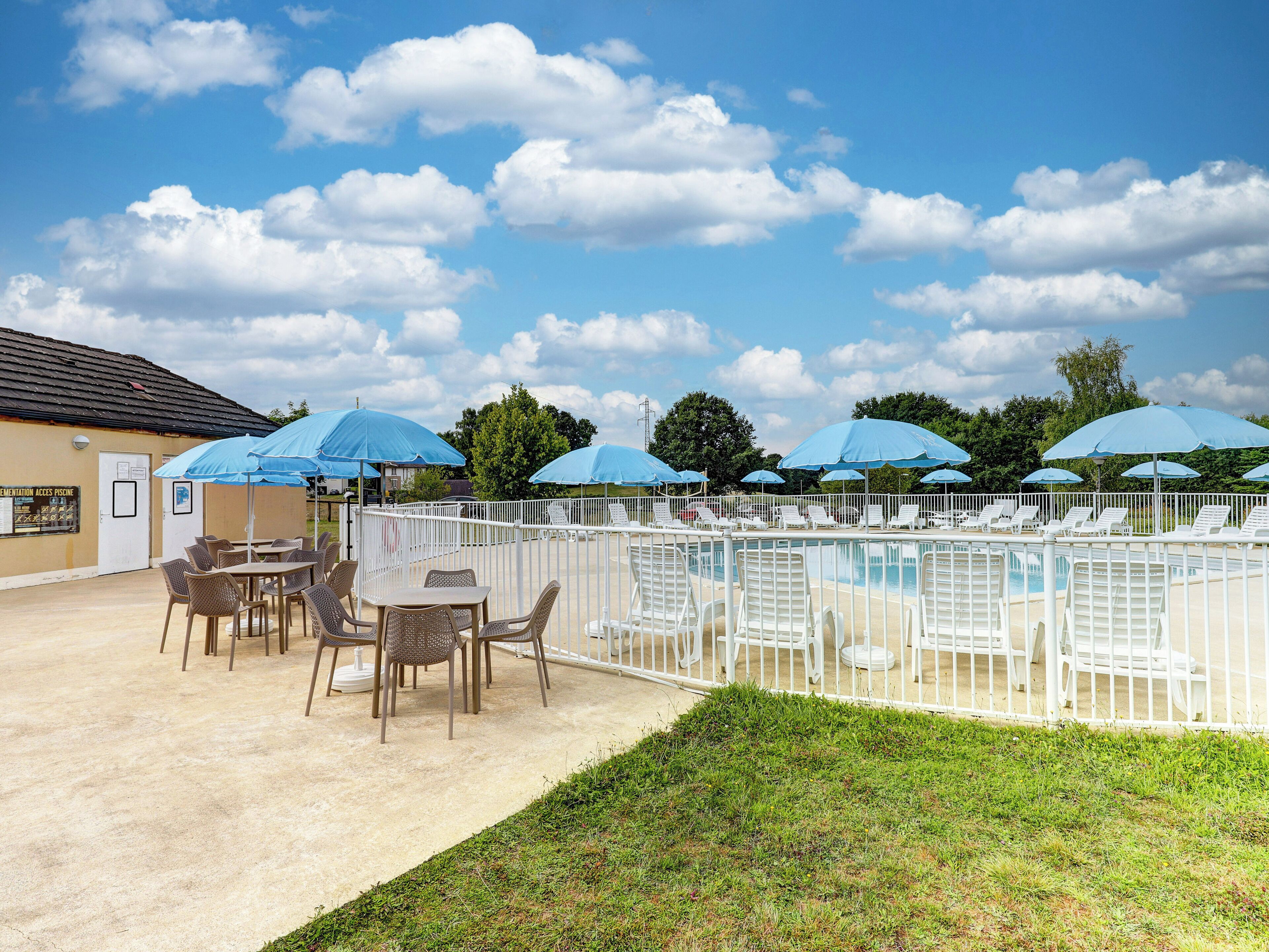 Een seizoensgebonden buitenzwembad en ligstoelen