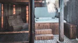 Una cabaña de madera con un jacuzzi, escalones de madera y una puerta de cristal.