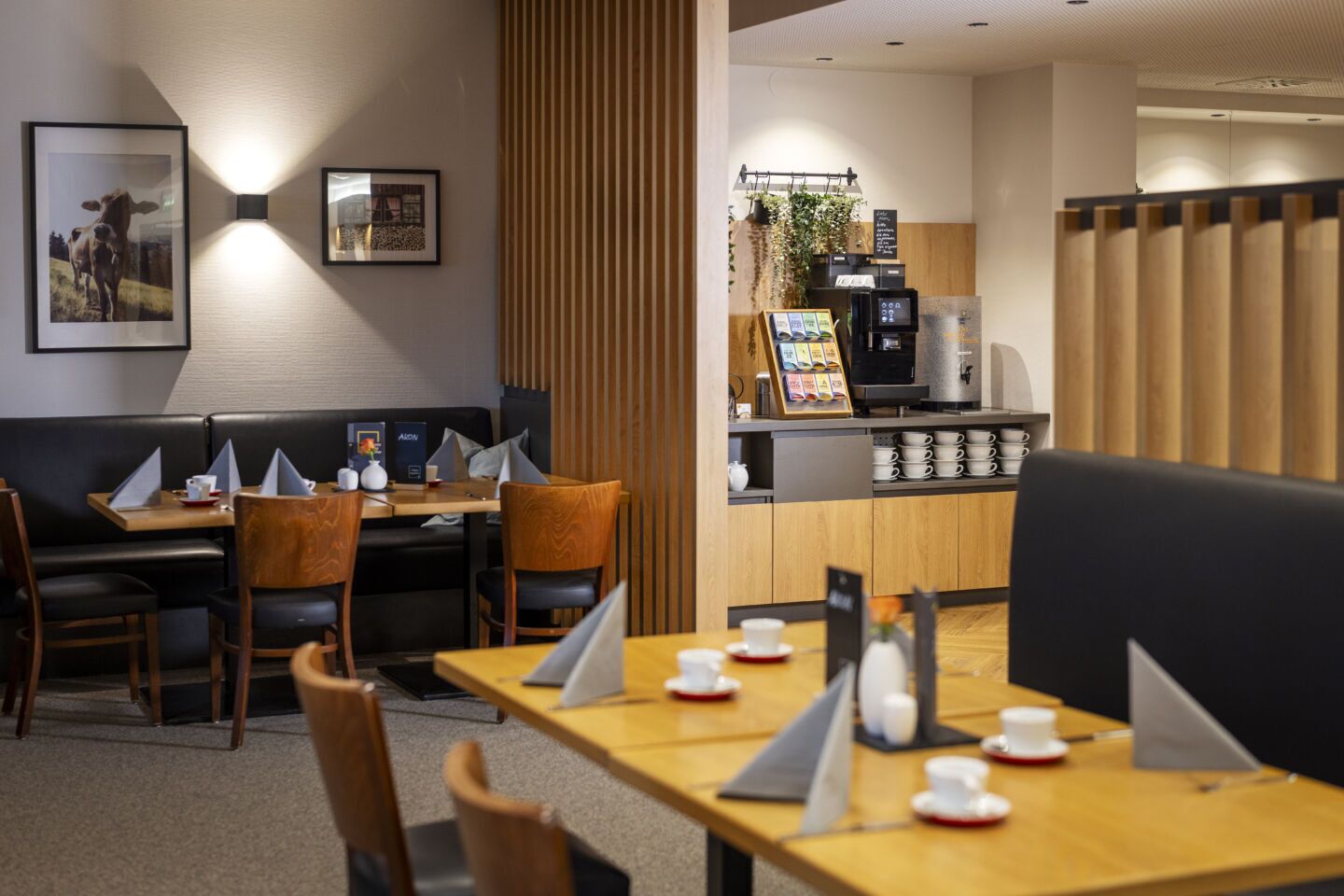 Um restaurante com cabines e mesas, uma máquina de café e um quadro de menu.