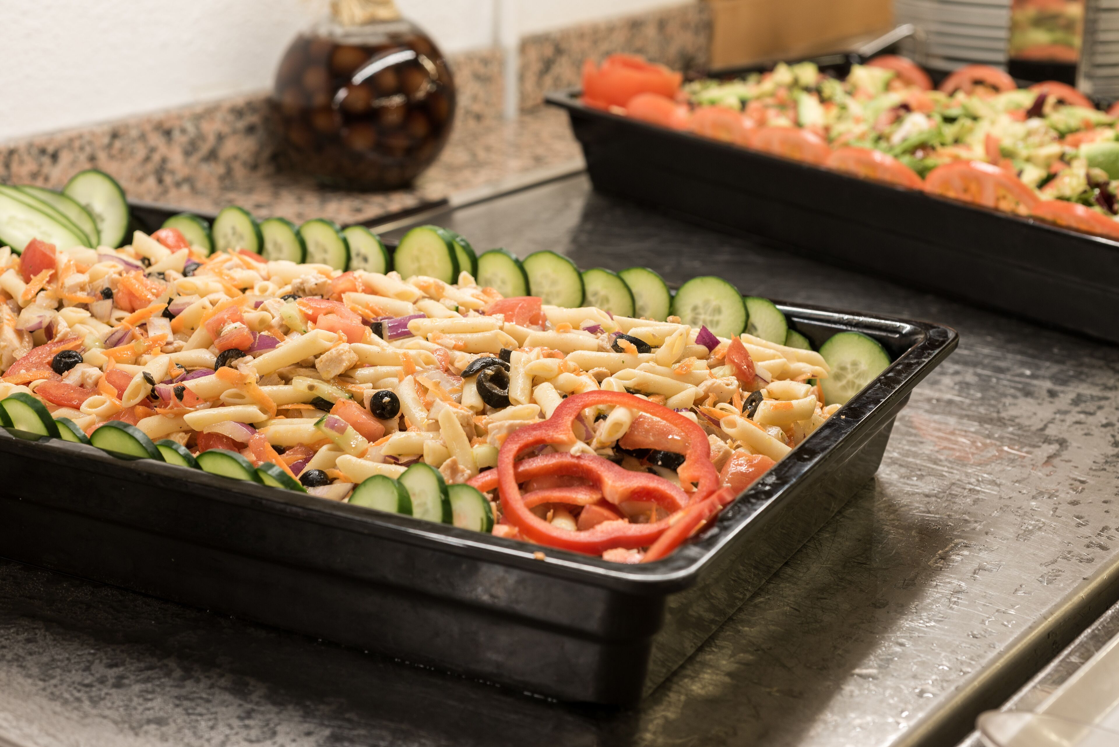 Una bandeja de ensalada de pasta con vegetales.